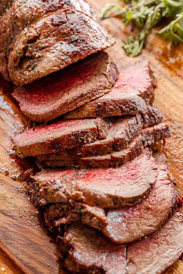 Make the most of your holiday meal with roasted beef tenderloin and homemade mushroom gravy. Simple, flavorful, and perfect for special occasions. Sliced beef roast on a cutting board.