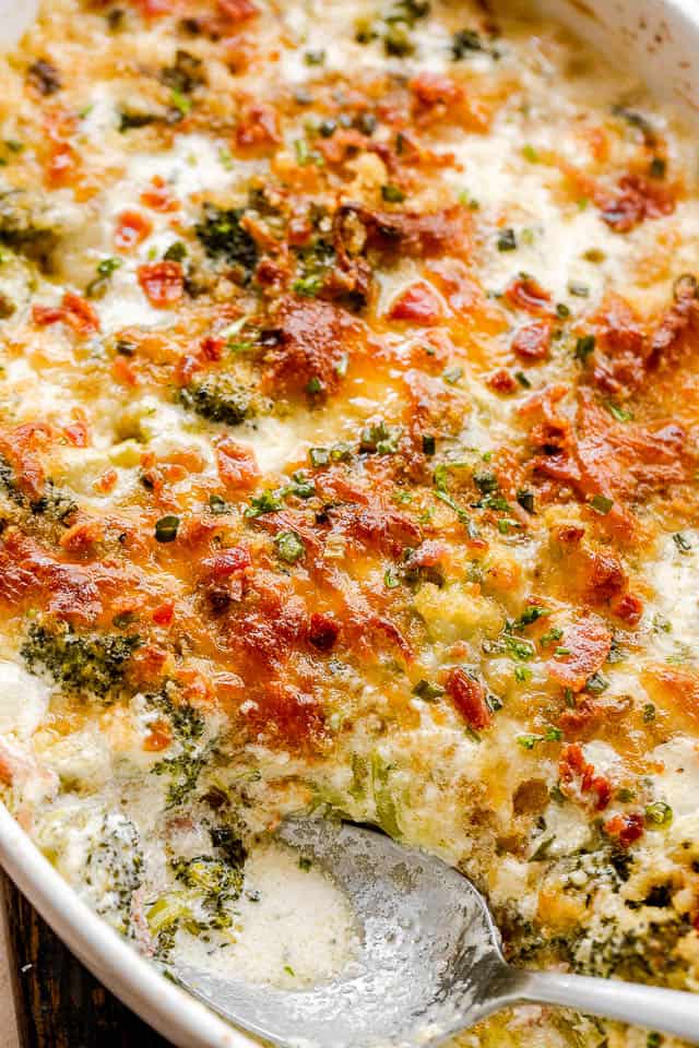 side shot of broccoli bacon cheese casserole in an oval baking dish