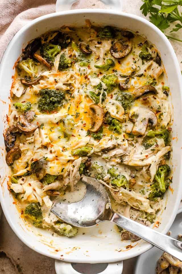 overhead shot of chicken broccoli casserole with a serving spoon inside the baking dish