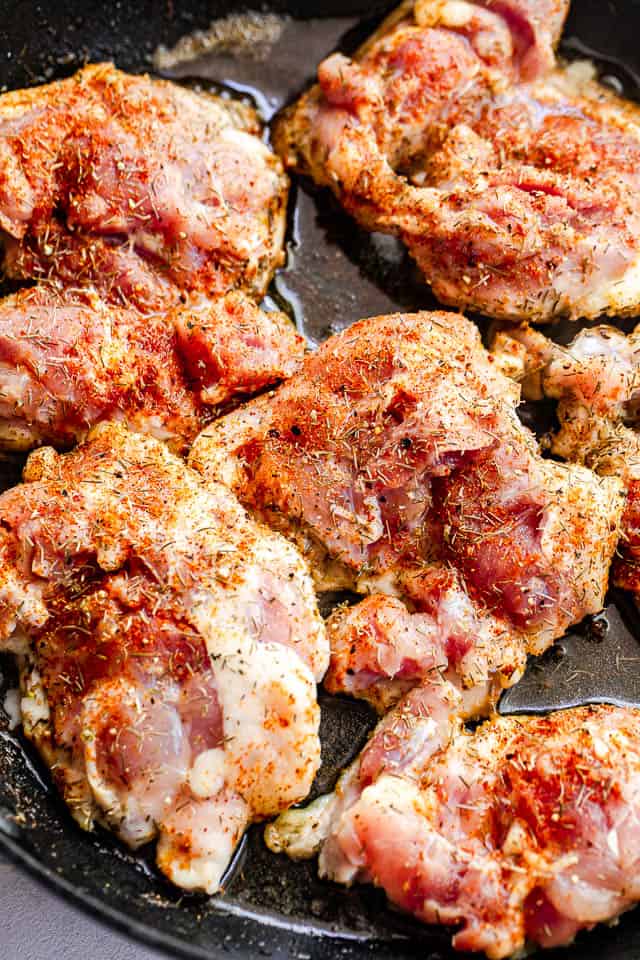 cooking boneless skinless chicken thighs in a black skillet