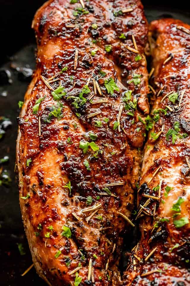 Top view of cooked pork tenderloin on a dark background.