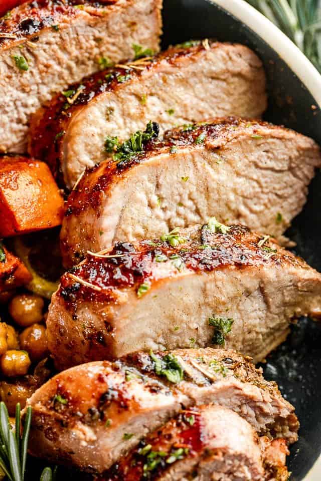 sliced pork tenderloin in a bowl served with vegetables