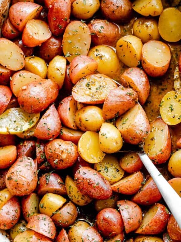 overhead shot of halved yellow and red small potatoes in a baking dish
