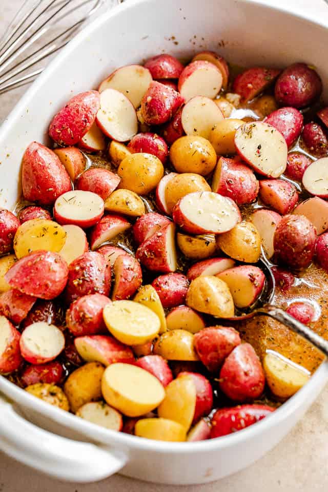 side above shot of a baking dish with halved small yellow and red potatoes
