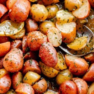 overhead shot of marinated halved yellow and red small potatoes in a baking dish
