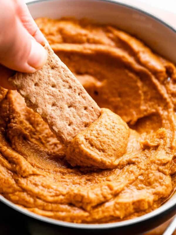 side shot of scooping out pumpkin peanut butter dip with a graham cracker