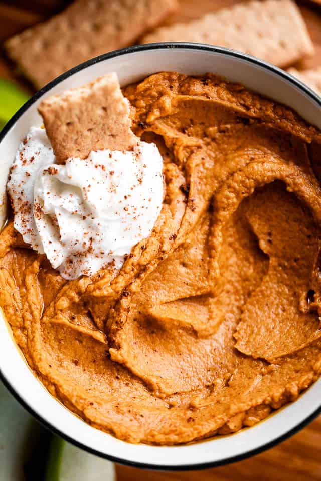 close up overhead shot of pumpkin dip in a bowl with a graham cracker