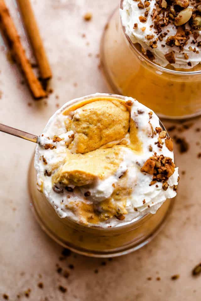 Photo of a spoon in a glass jar filled with pumpkin mousse.