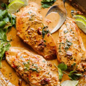 overhead shot of chicken breasts in a skillet with creamy chipotle sauce with cilantro
