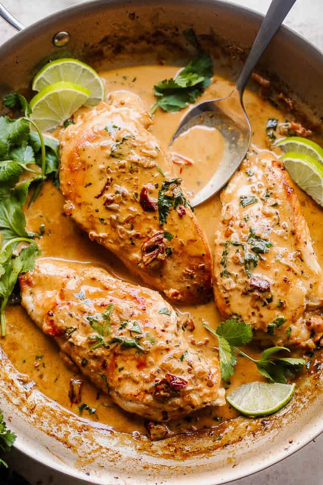 overhead shot of chicken breasts in a skillet with creamy chipotle sauce with cilantro