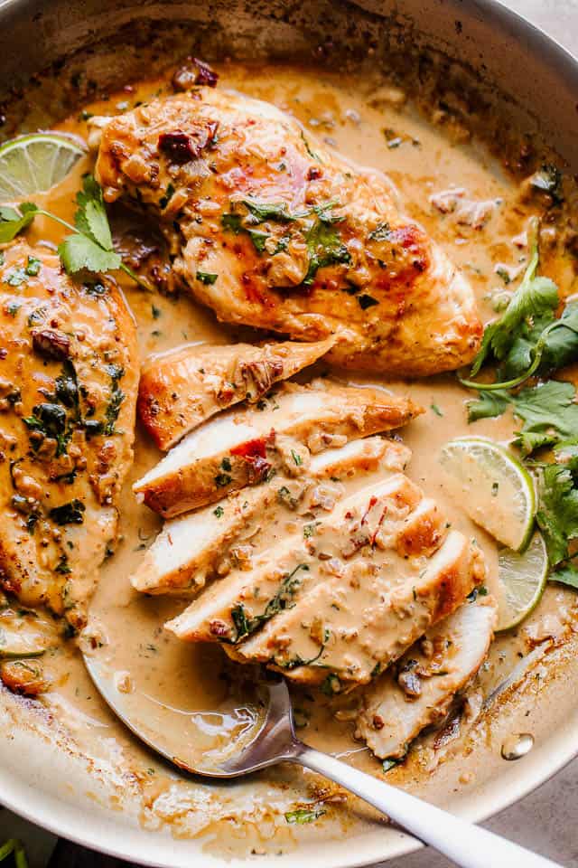 overhead shot of sliced chicken breasts in skillet with creamy chipotle sauce