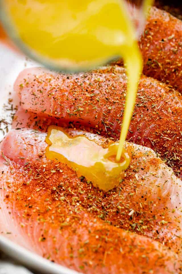 pouring melted butter over fish fillets