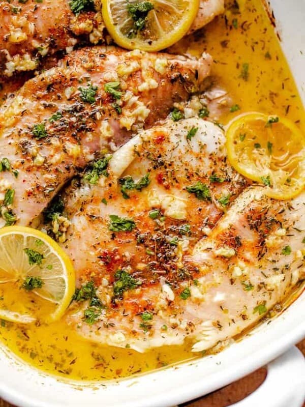 tilapia fillet topped with herbs and lemon slices