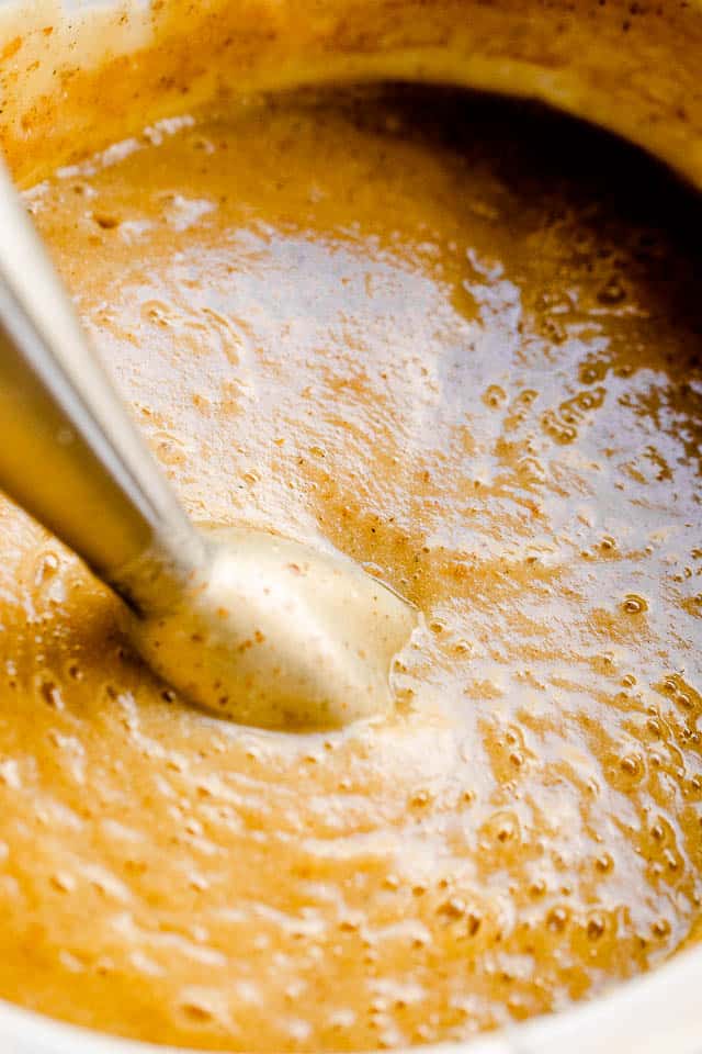 blending slow cooker cauliflower cheese soup with immersion blender