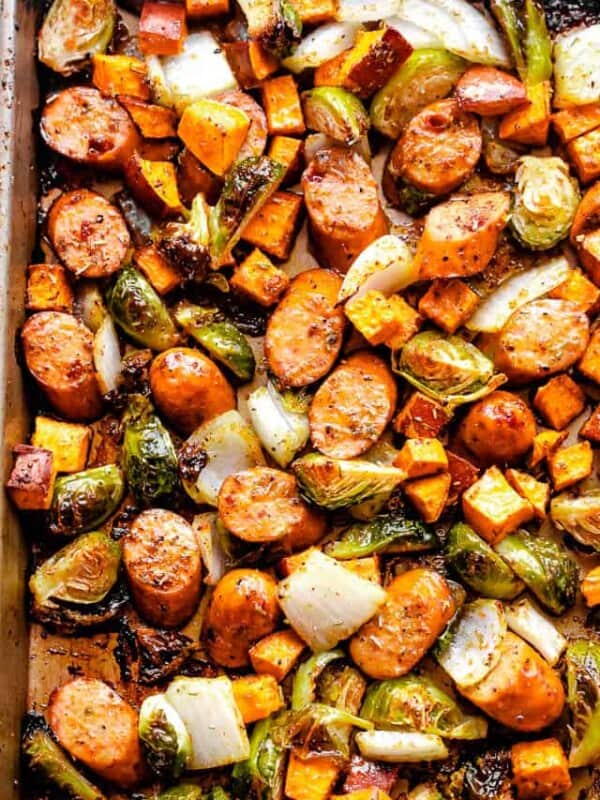 overhead shot of a sheet pan with cooked andouille sausage, brussels sprouts, and sweet potatoes