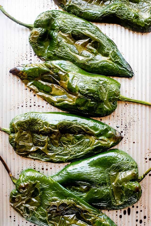 Roasted poblano peppers on a baking sheet.