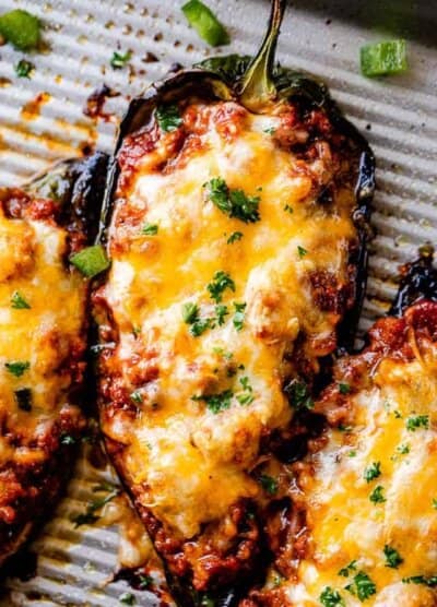 close up shot of chili stuffed poblano peppers topped with melty cheese