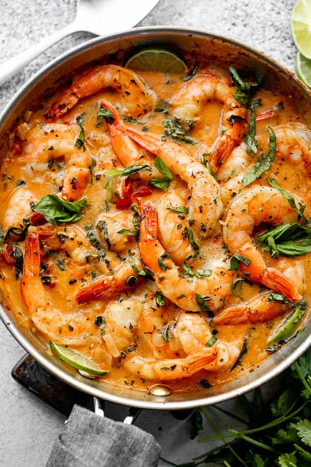 wide overhead shot of shrimp in a skillet with coconut sauce