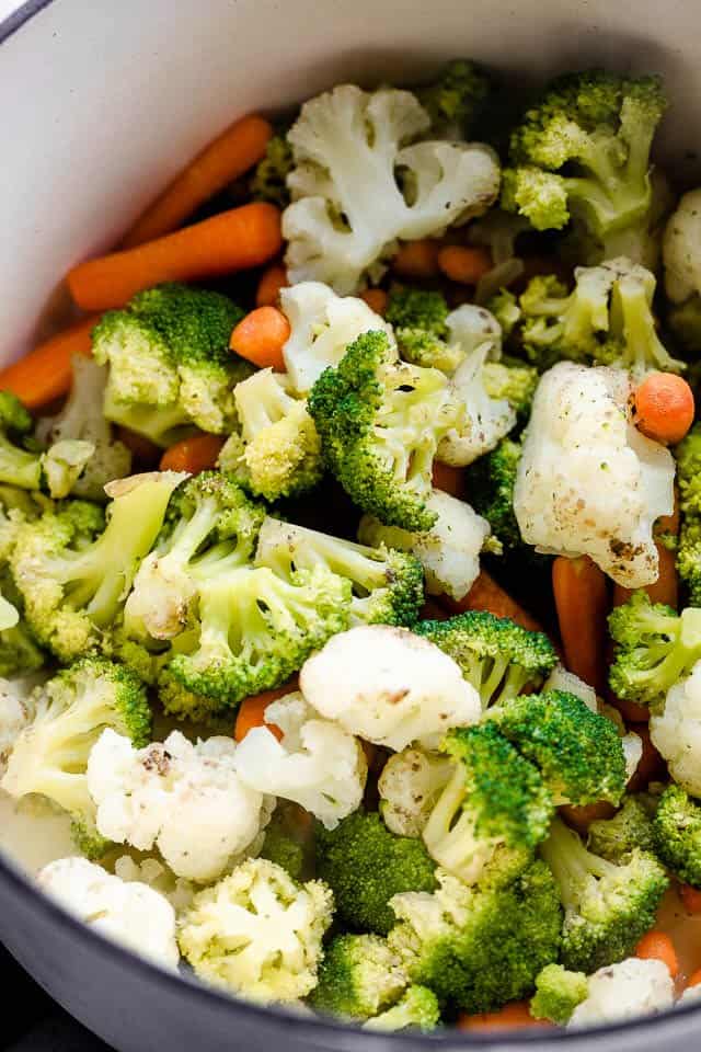 Boiling cauliflower, broccoli, and carrots in a stockpot.