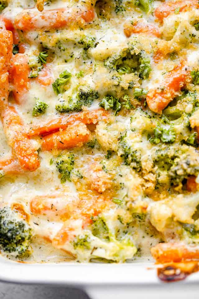 overhead close up shot of broccoli and carrots in a cream sauce