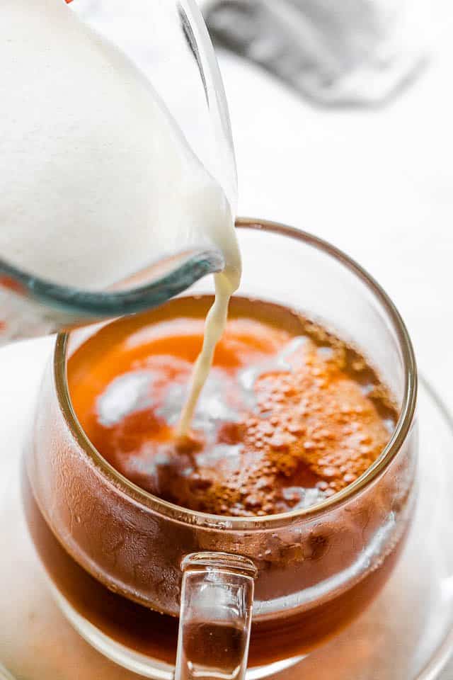 Pouring hot milk into earl grey tea