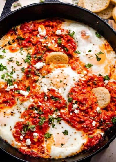 overhead shot of ajvar mixed with eggs and served with bruschettini toasts