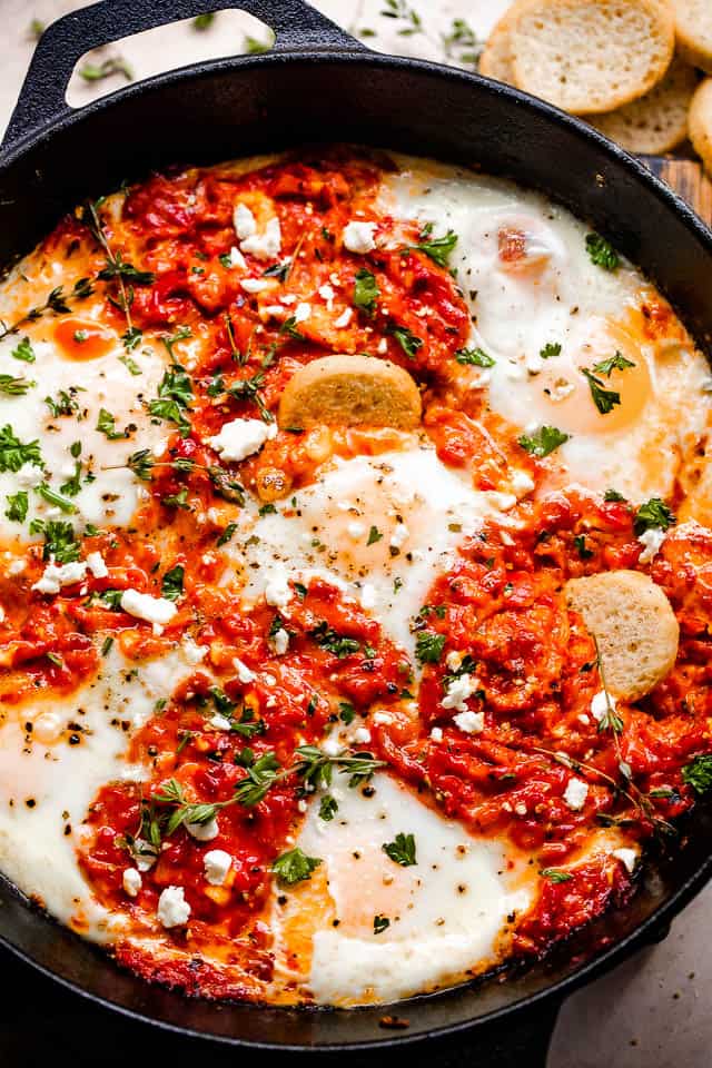 overhead shot of ajvar mixed with eggs and served with bruschettini toasts
