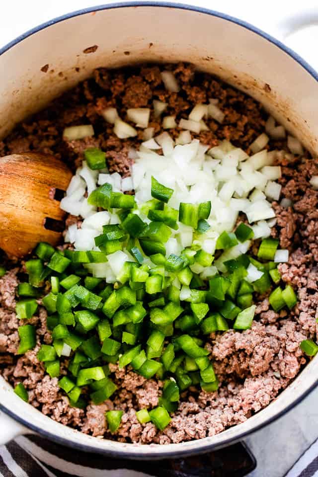 Overhead shot of sauteed ground beef with green diced peppers and diced onions.