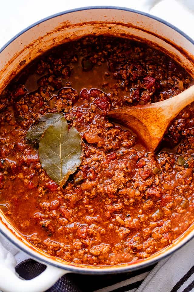 Overhead shot of a cooked no beans chili in a white dutch oven.