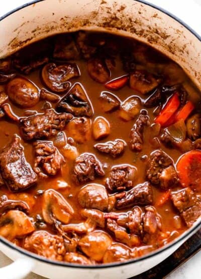 cooking Beef Bourguignon in a white dutch oven