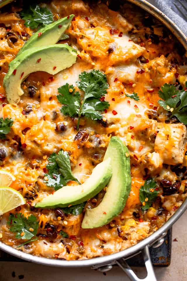 Close-up shot of chicken casserole topped with avocado slices and cilantro.