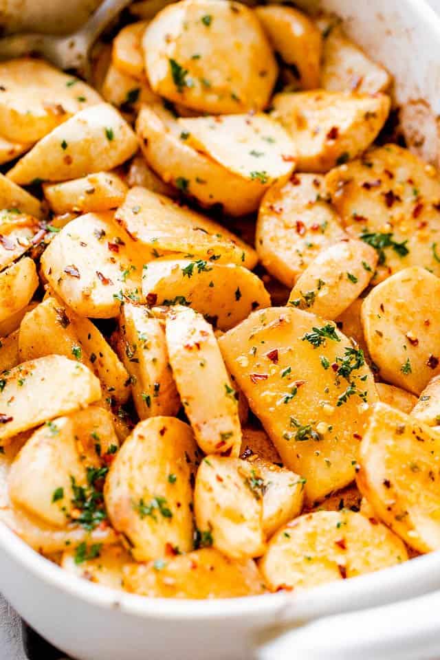 side shot of a baking dish with roasted turnips topped with herbs and pepper flakes