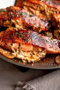 side shot of creamy stuffed cajun salmon fillets in a skillet