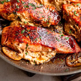 Salmon fillets cooking in a skillet.