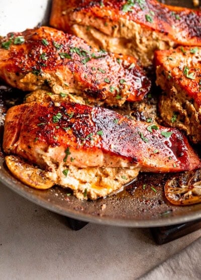 Salmon fillets cooking in a skillet.