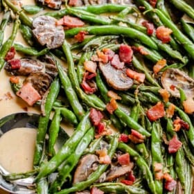 green beans and mushrooms cooking in a creamy parmesan sauce and topped with diced bacon