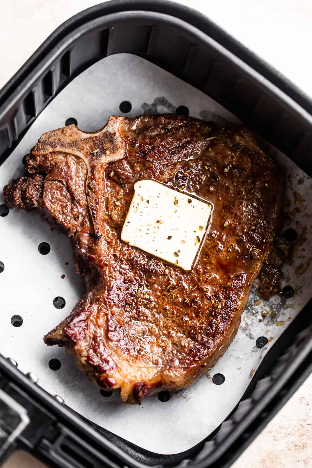 Cooked steak in an air fryer with butter