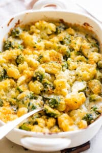 white baking dish with cauliflower and brussel sprouts casserole topped with a crumb mixture