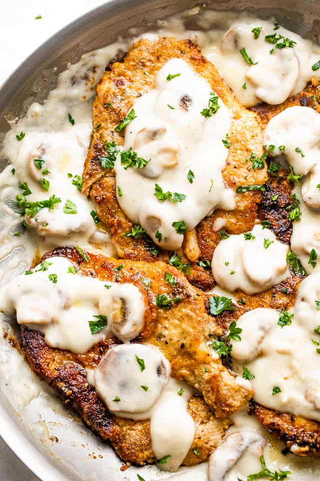 overhead photo of fried pork chops topped with mushroom cream marsala sauce