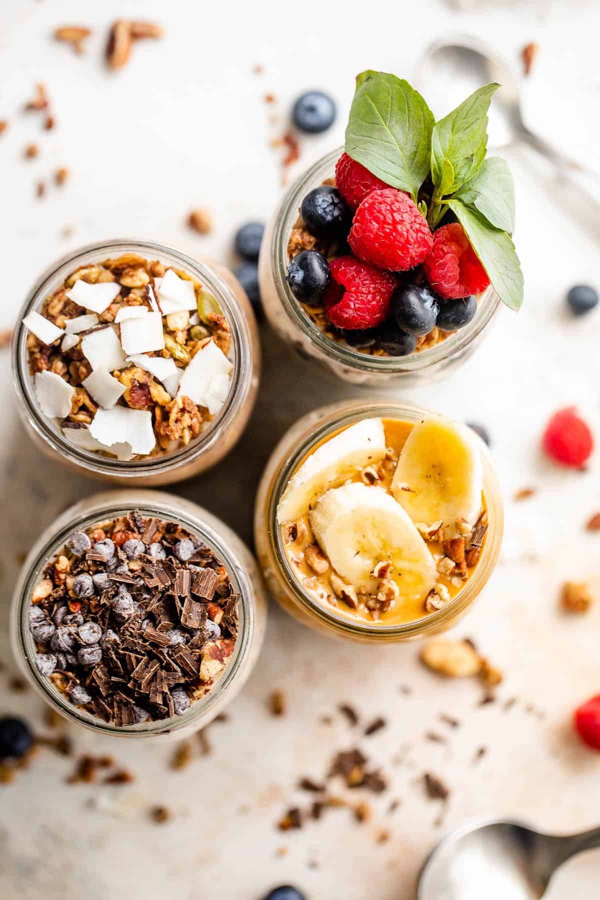 overhead shot of overnight oatmeal in jars topped with various ingredients