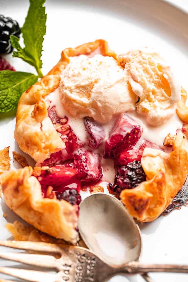 Mini Berry Galettes topped with vanilla ice cream scoop.