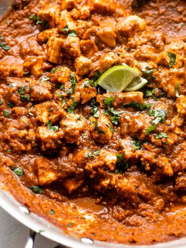 close up shot of sofritas in a skillet garnished with lime slices and cilantro