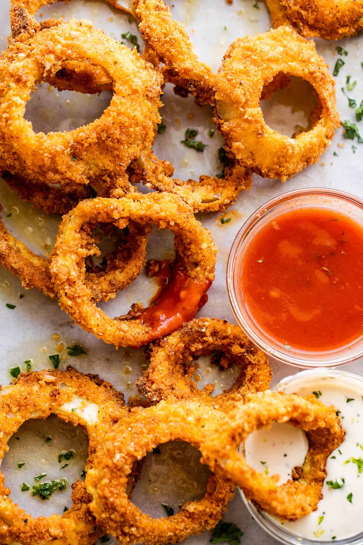 overhead photo of air fryer onion rings served with ketchup and ranch