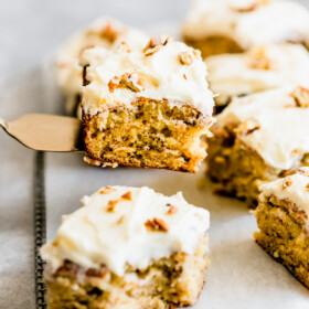 Lifting up a square of banana cake with a spatula.