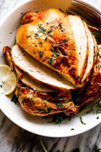 whole roast chicken in a white bowl