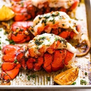 Four Cooked Lobster Tails Lined Up on a Baking Sheet