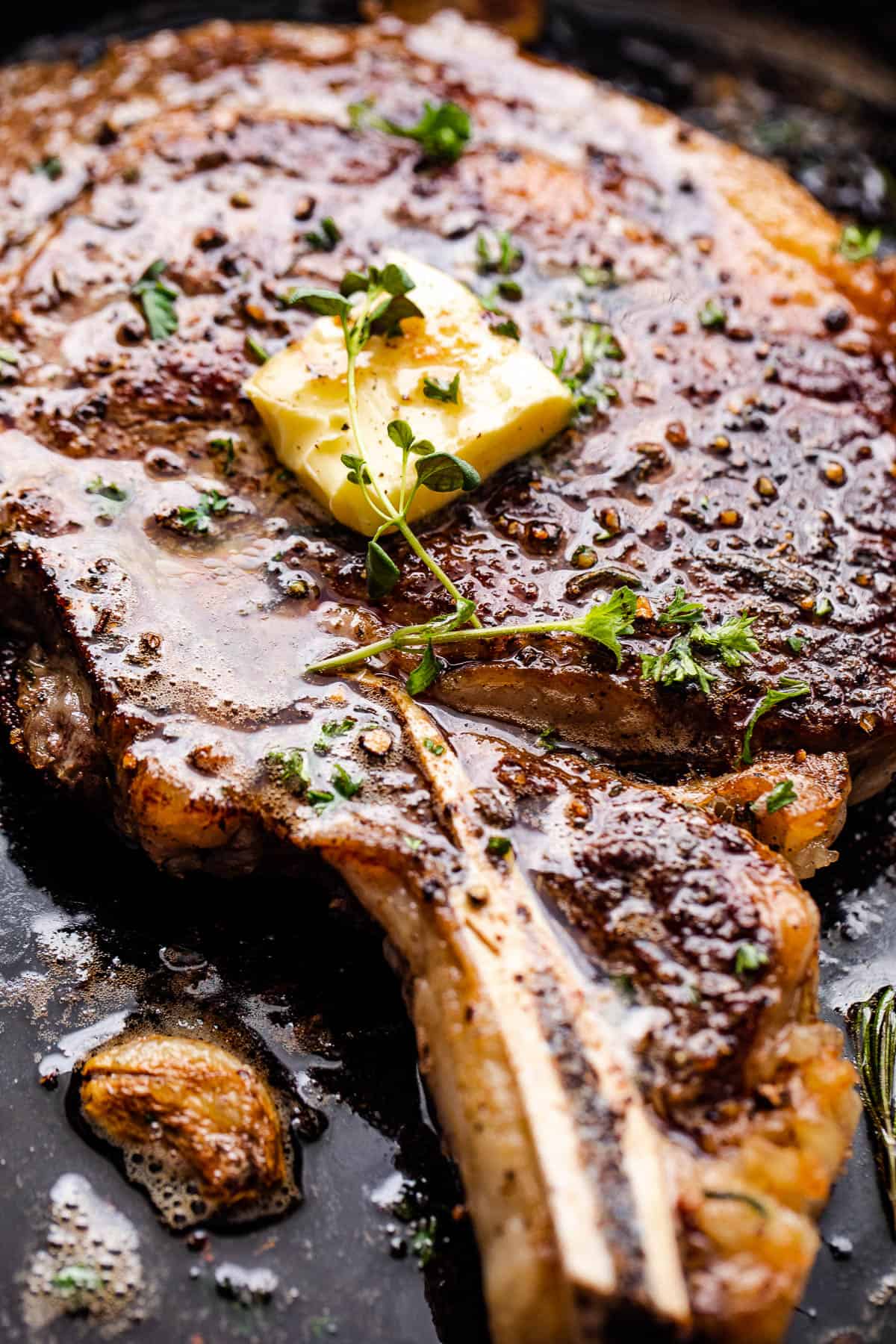 side shot of cooking ribeye steak in a skillet