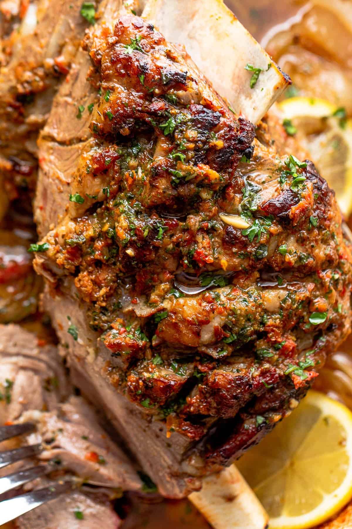 Close-up shot of cooked lamb shoulder with a garlicky sundried tomato crust.