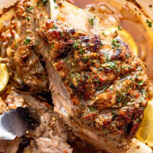 cooked lamb shoulder in a white roasting pan