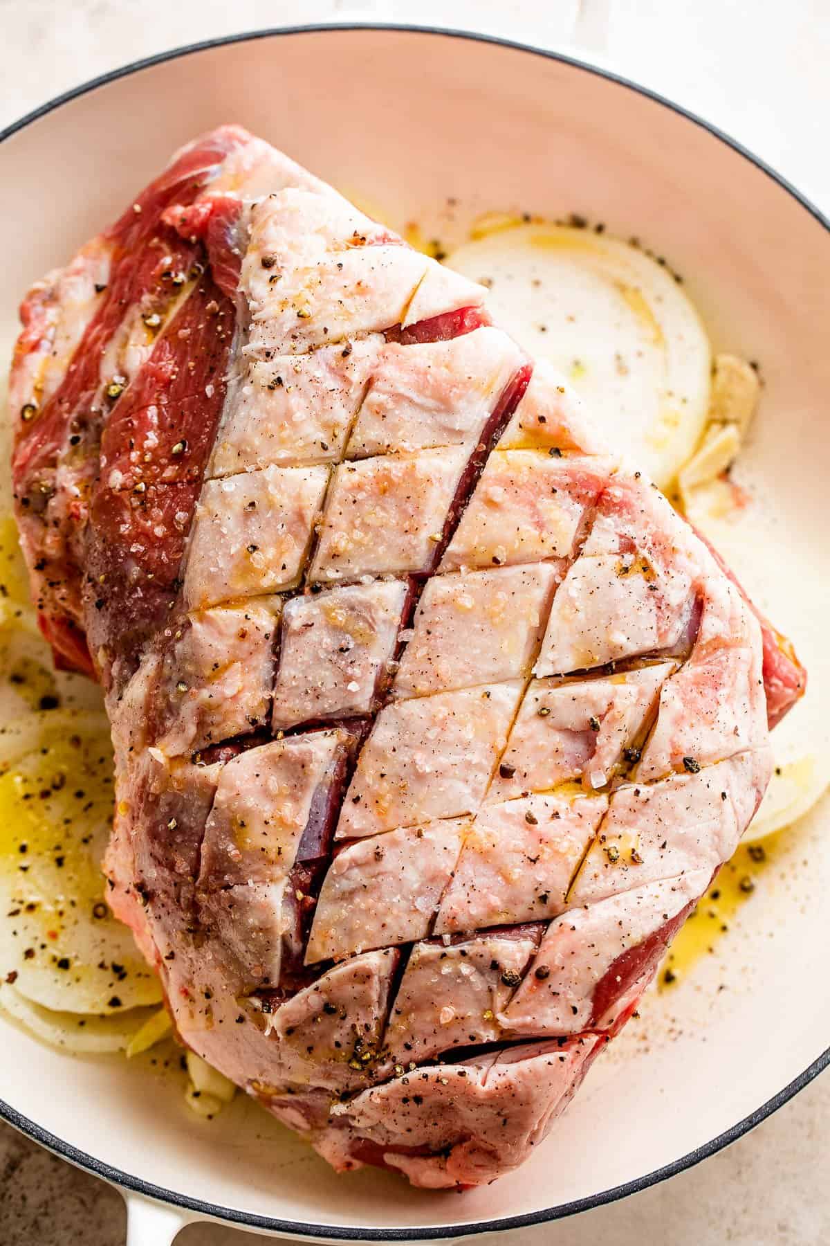 raw lamb shoulder with fat cap up and slashed into a diamond pattern